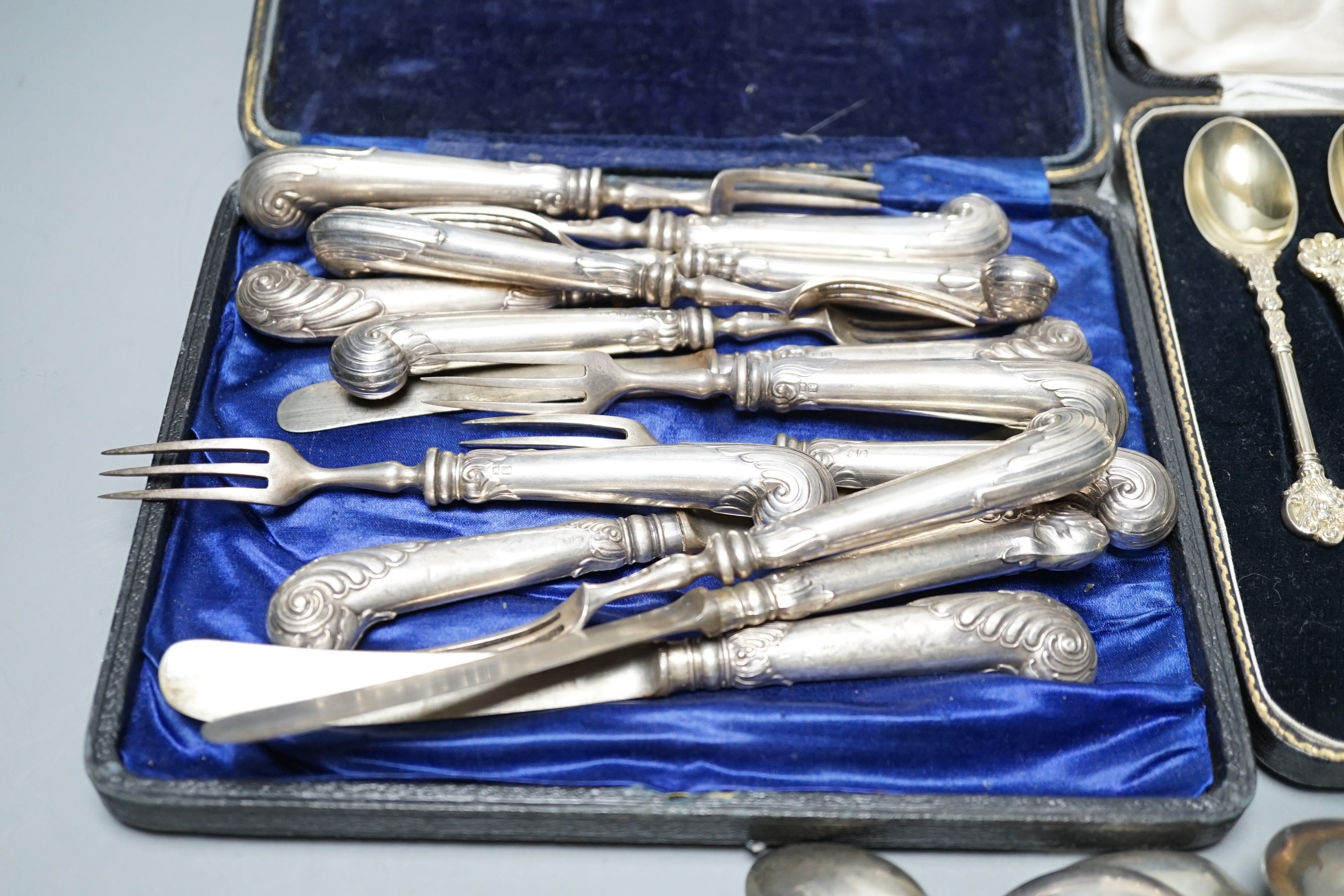 A cased set of twelve Victorian silver gilt teaspoons, London, 1894, six pairs of Edwardian silver pistol handled dessert eaters and four other forks, a set of six Malaysian white metal spoons, a set of six silver coffee